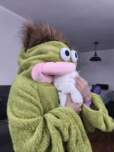 Customer in the green Silly Onesie holding a pet